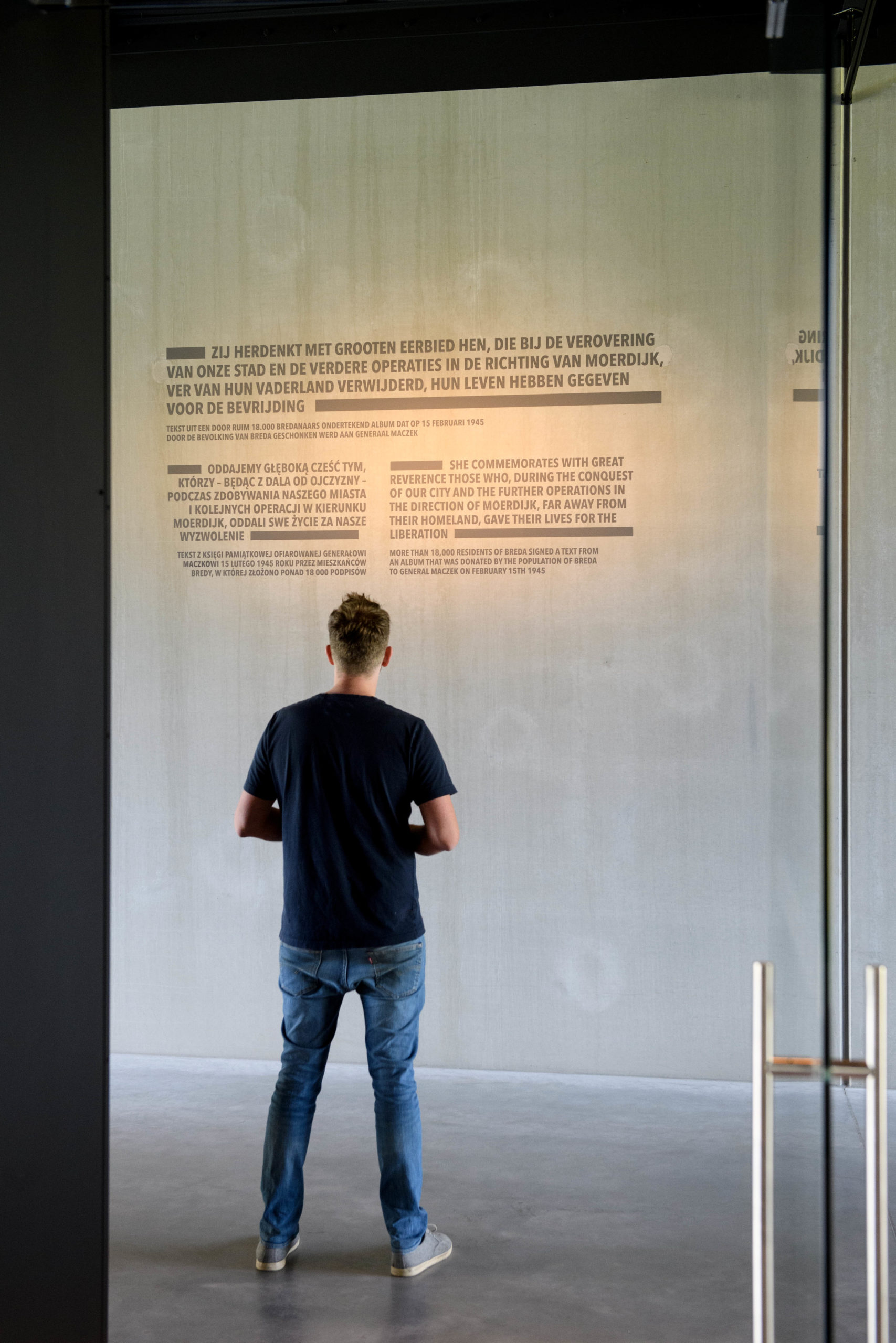 Een man kijkt naar tekst op een grote witte muur