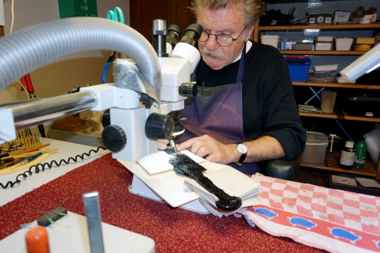 Erfgoedvrijwilliger Ronald restaureert met beheulp van een machine een flensmes