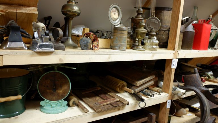 Oude voorwerpen uitgestald op een houten stellingkast