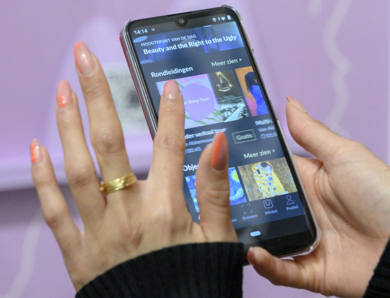 Vrouw die mobiele museum app bedient.