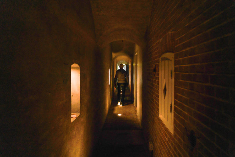 Erfgoedvrijwilliger Arnold wandelt door het gangenstelsel van het fort Kunstfort Vijfhuizen